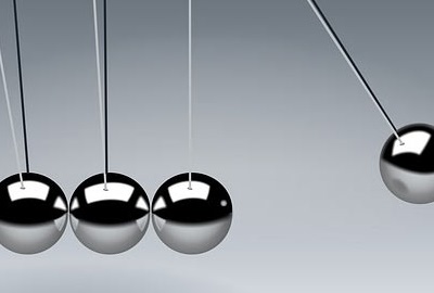 Newton's cradle which demonstrates conservation of momentum and energy using a series of swinging spheres, signifying the importance to balance end-user needs.