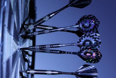 Image of darts on a dartboard representing the need to not make project assumptions.